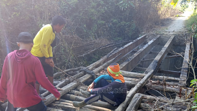 Sejumlah warga meratapi sisa jembatan yang hangus habis terbakar di Jembatan Maor Clebung, Bubulan. Foto : Alham M. Ubey